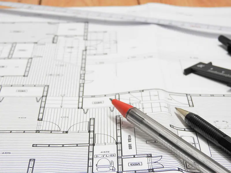 設計図の上にペンが置かれた画像