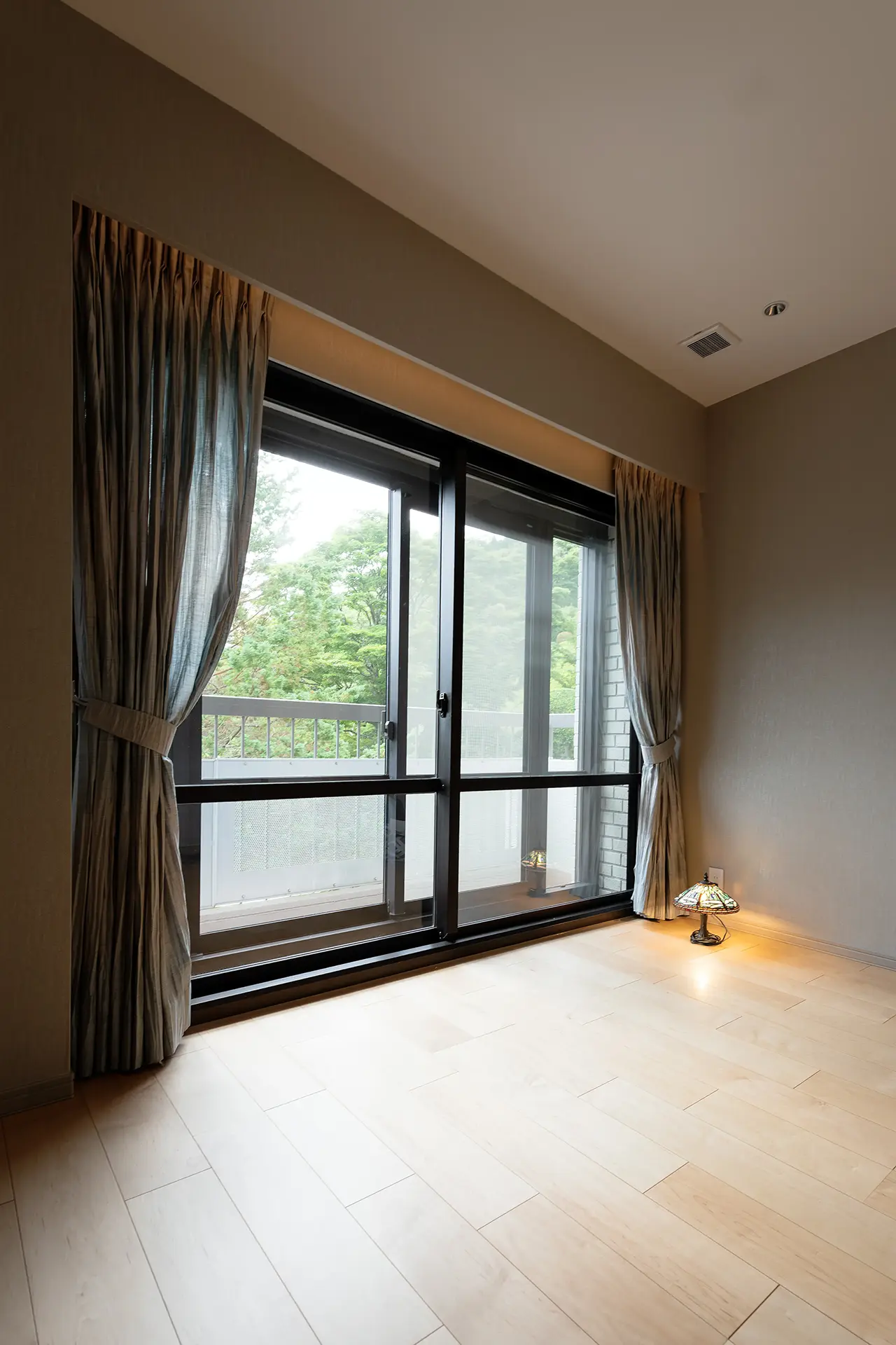 寝室のカーテンを開けると外の緑が見える