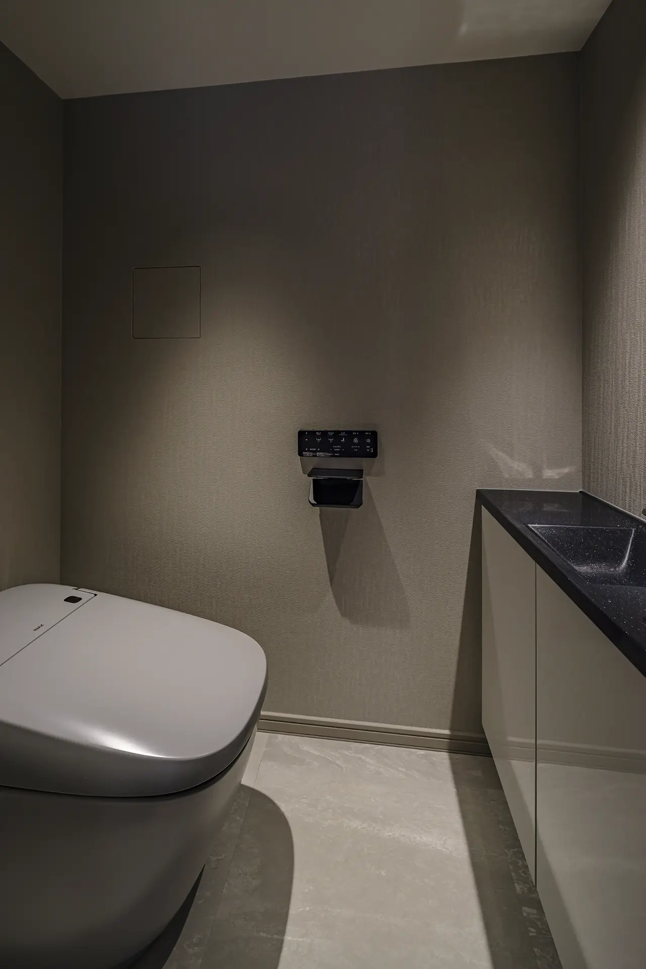 居室とは対象的なシックな色使いのトイレ