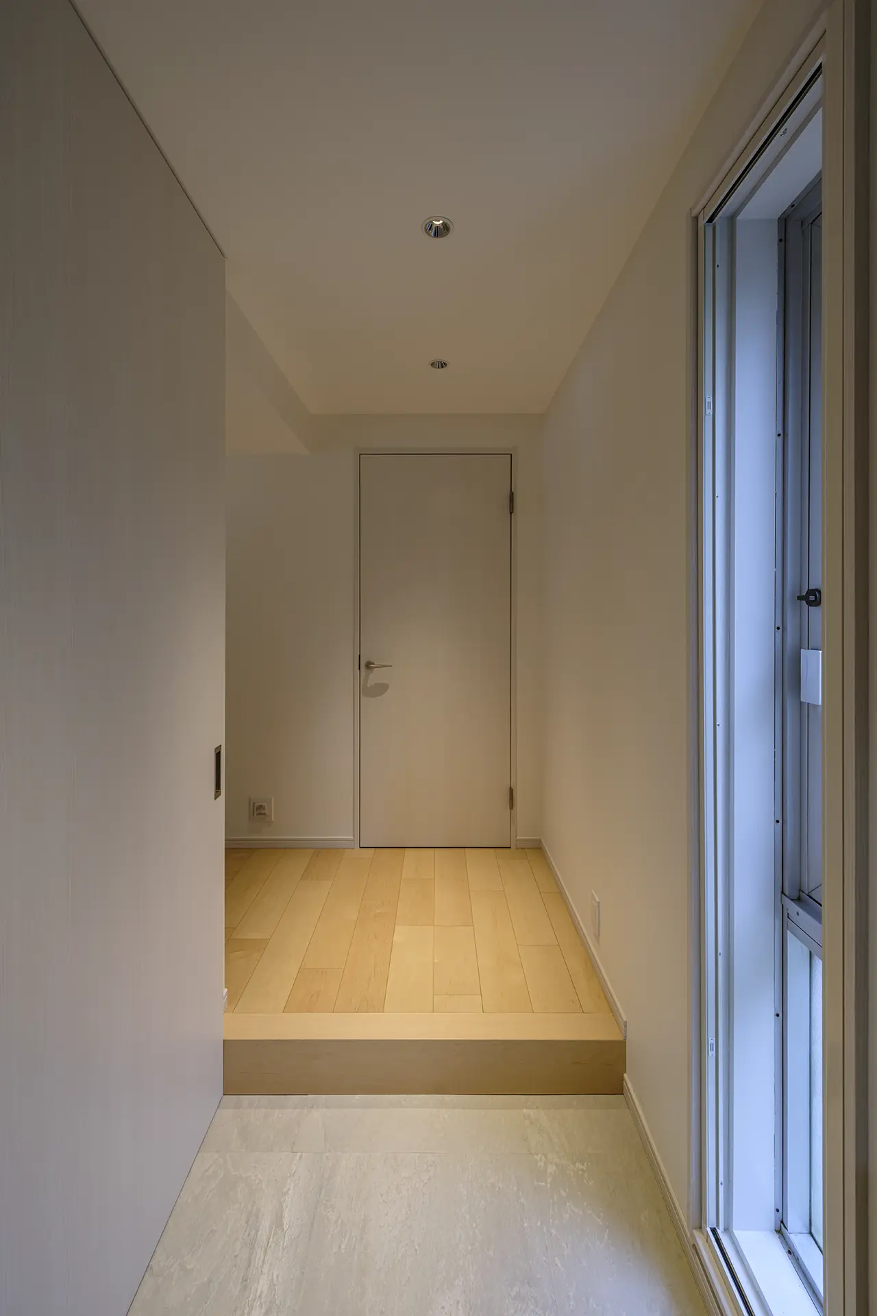 開放的なLDKへとつながるシンプルなデザインの玄関。正面は書斎への入口