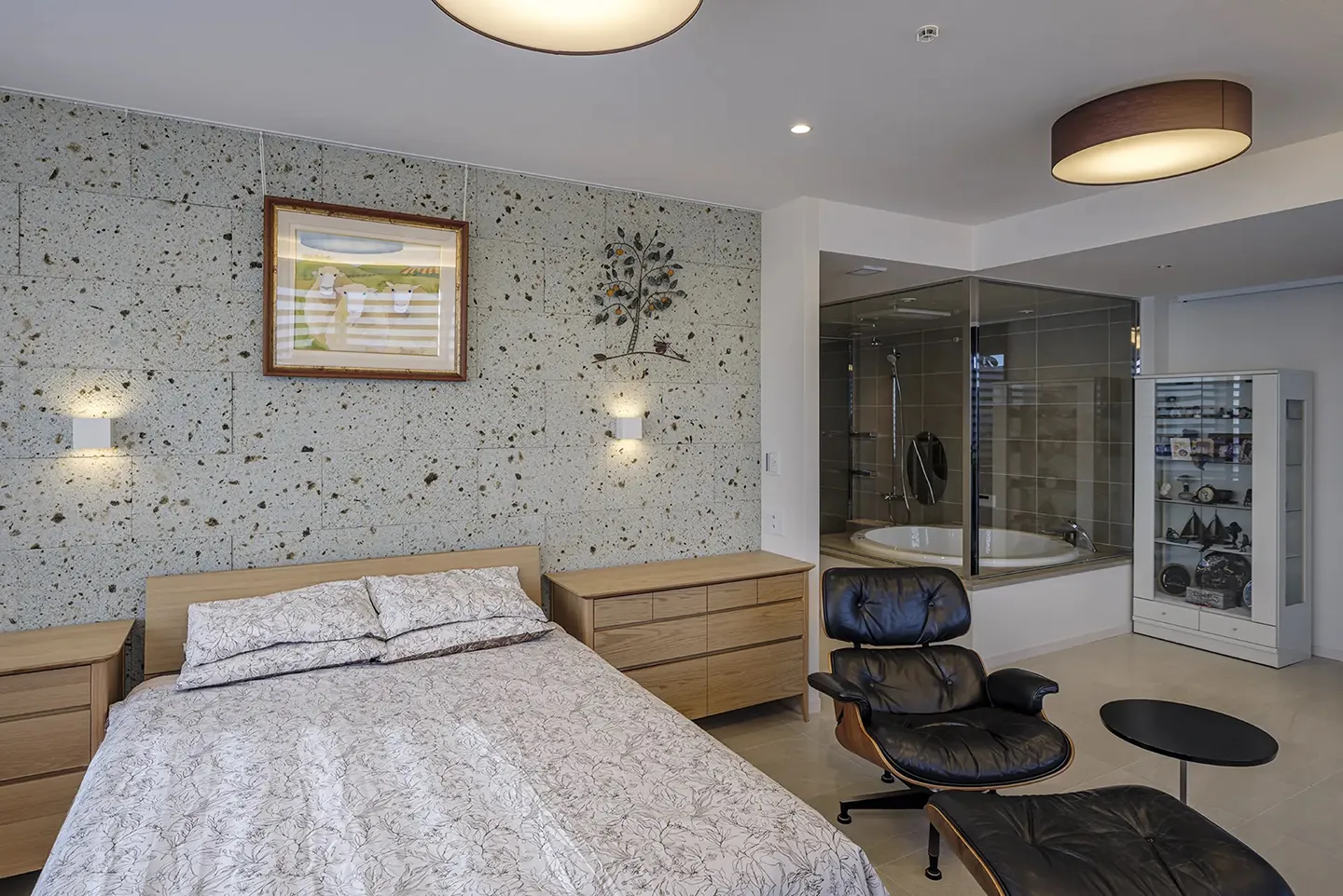 壁面に大谷石が配された自然な温かみが感じられるベッドルーム